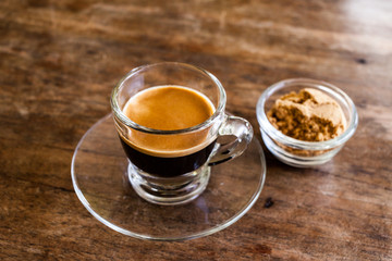 Cup of hot espresso coffee on wooden table.