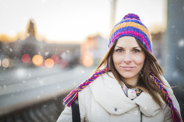 Positive girl with colorfull hat in winter city - 75762646
