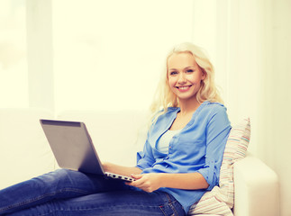 smiling woman with laptop computer at home