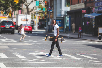 Black Boy Walking in the City Holding Longboard