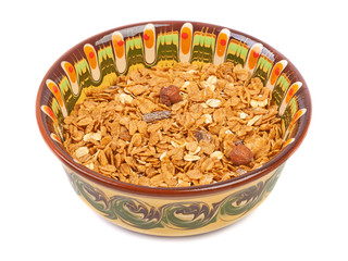 Bowl of oatmeall with fruit on a plate, isolated on white