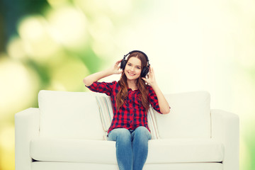 Obraz premium teenage girl sitting on sofa with headphones