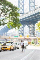 Black Boy Skating with Longboard on the Road