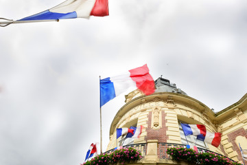 French flag waiving over some Hotel de Ville