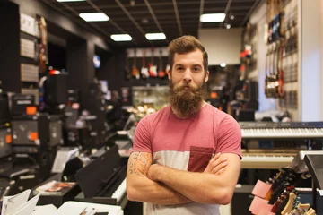 Abwaschbare Fototapete Musikladen Assistent oder Kunde mit Bart im Musikladen