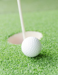 golf ball on lip of cup