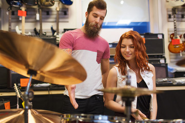 Fototapeta na wymiar man and woman with drum kit at music store