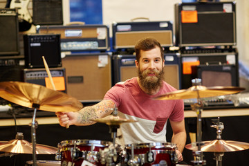 male musician playing cymbals at music store