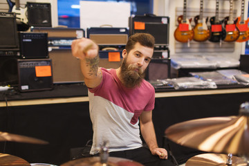 male musician playing cymbals at music store