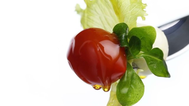 fork lettuce salad leaves, tomato and mozzarella topped with oli