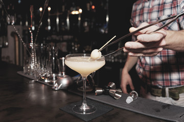 Bartender is making a cocktail with leechee, toned