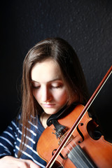 Beautiful, young violinist playing violin, close-up