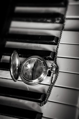 Pocket watch on old keyboard piano - 75771461