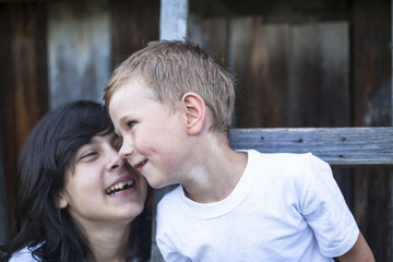 Naklejka premium Little boy plays with his older sister in outdoors.