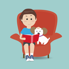 boy reading the book on the sofa with his dog
