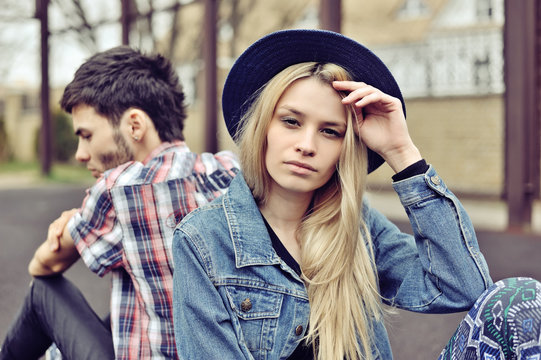 Depressed couple. Depressed young hipsters couple sitting back t