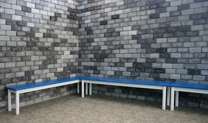 blue  bench with old brick wall