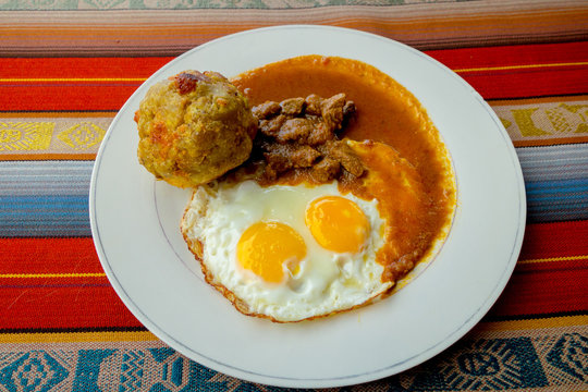 Bolon de verde with fried egg and meat stew ecuadorian food