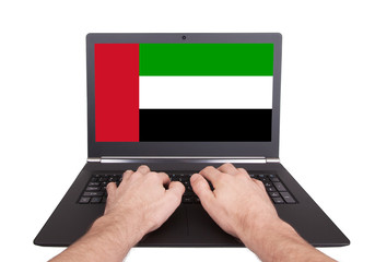 Hands working on laptop, UAE
