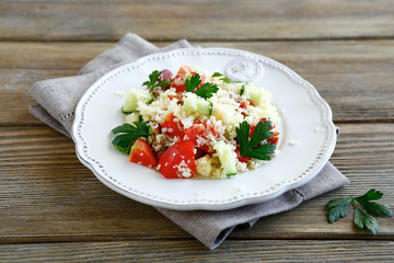 Delicious salad with arabic couscous and vegetables on a plate