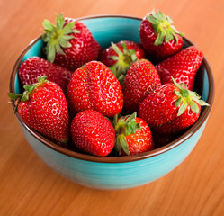 Strawberries in a Bowl, ona a wooden background