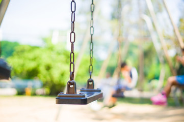 Set of chain swings on modern kids playground, kids swinging on