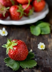 Fresh strawberries on a wooden background with leaf.