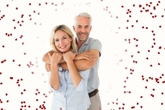 Composite image of happy couple standing and hugging