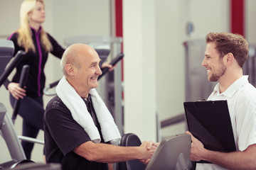 älterer mann schüttelt trainer die hand