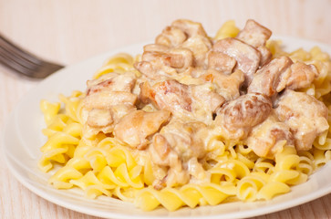 Sliced fried chicken in a creamy sauce. with fusilli pasta
