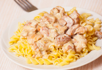 Sliced fried chicken in a creamy sauce. with fusilli pasta
