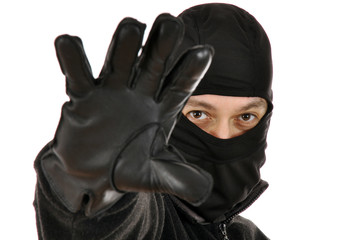 Einbrecher trägt Sturmhaube und Lederhandschuhe