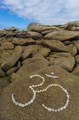 Symbol Om aus großen Kieselsteinen in Felsenlandschaft
