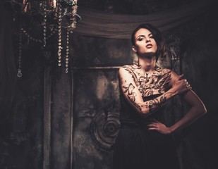 Tattooed beautiful woman in old spooky interior