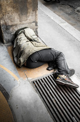 senzatetto sdraiato per terra che dorme