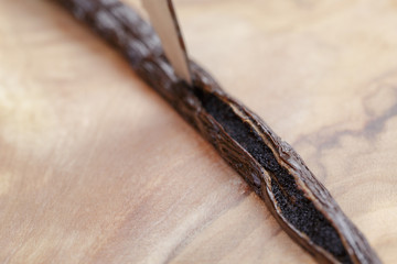 open vanilla pod on olive board