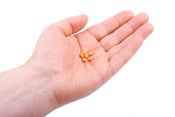 Hand holding  pills. Isolated on white background