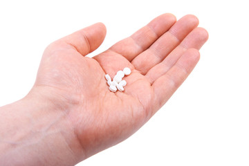 Hand holding  pills. Isolated on white background