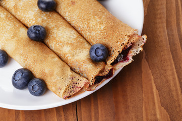 homemade blinis with blueberries and jam, on wooden table