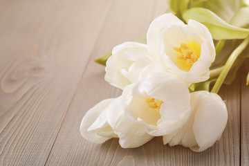 Obraz na płótnie Canvas beautiful white tulips on wooden background with copy space
