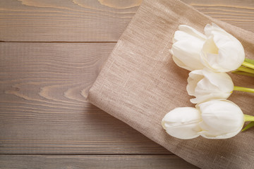 Fototapeta na wymiar beautiful white tulips on wooden background with copy space