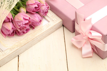 Flowers and gift box on wooden background with copyspace