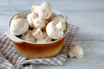 Raw mushrooms in a bowl on napkin