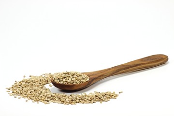 Sesam mit Löffel aus Olivenholz isoliert auf weißem Hintergrund