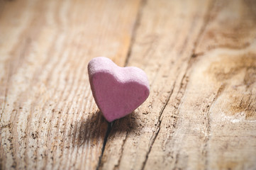 The pink heart on a wooden rustic table as background