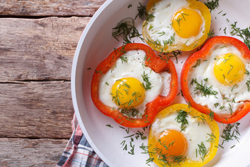 fried eggs with peppers on a pan close-up. top view horizontal