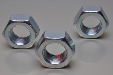 Group of steel nuts with light reflection