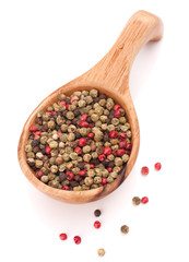 Black, green and pink pepper peppercorn mix in wooden spoon isol