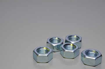 Group of steel nuts with light reflection