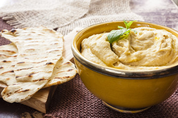 Hummus in a bowl and pita bread